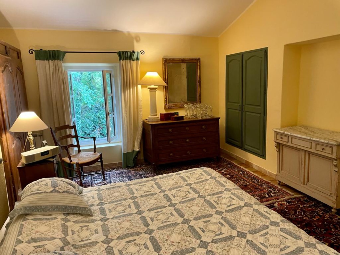 Chambre aux murs ocre jaune, boiseries et penderie repeintes