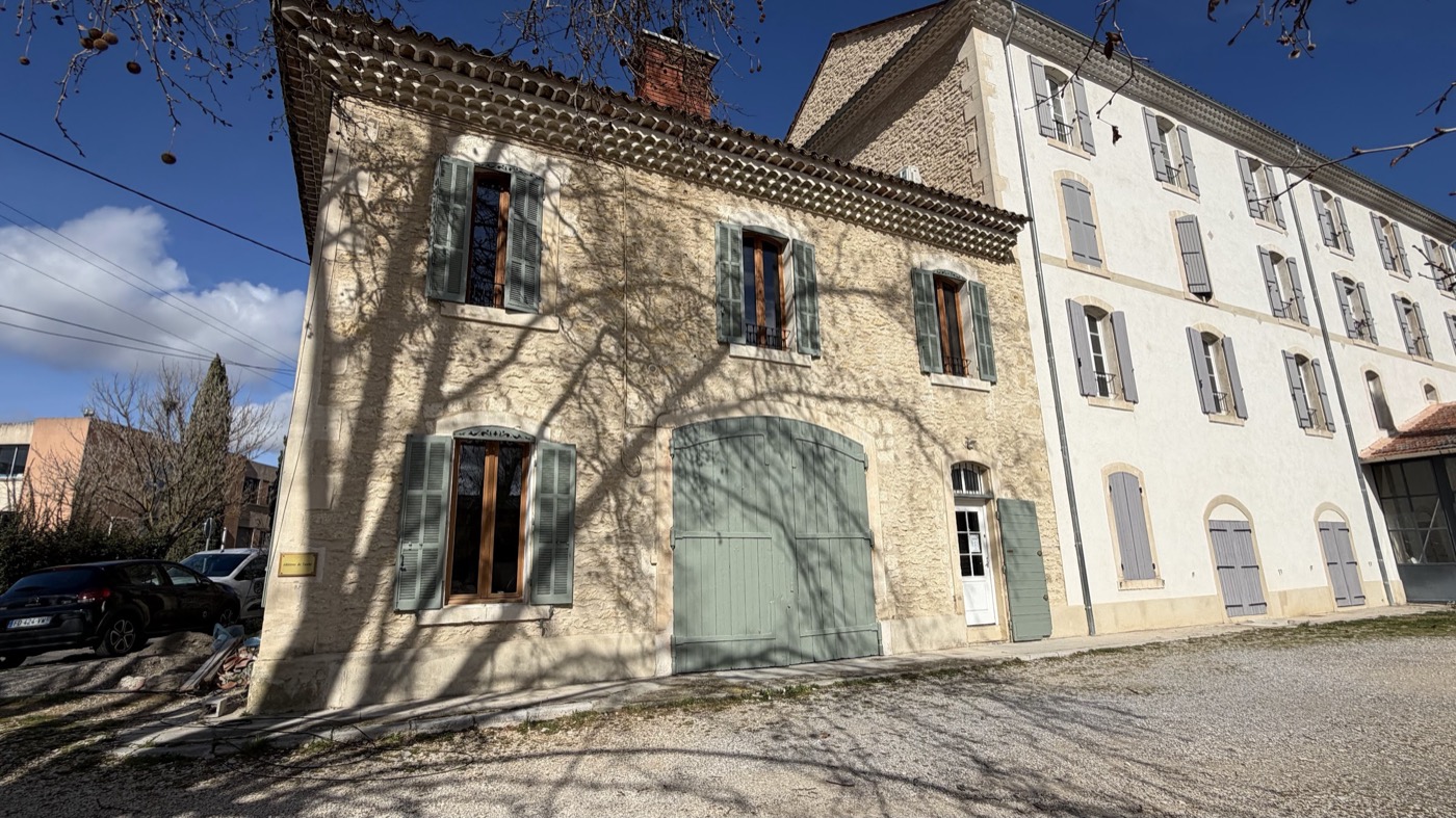 Façade d'un mas provençal en pierre, volets vert d'eau repeints