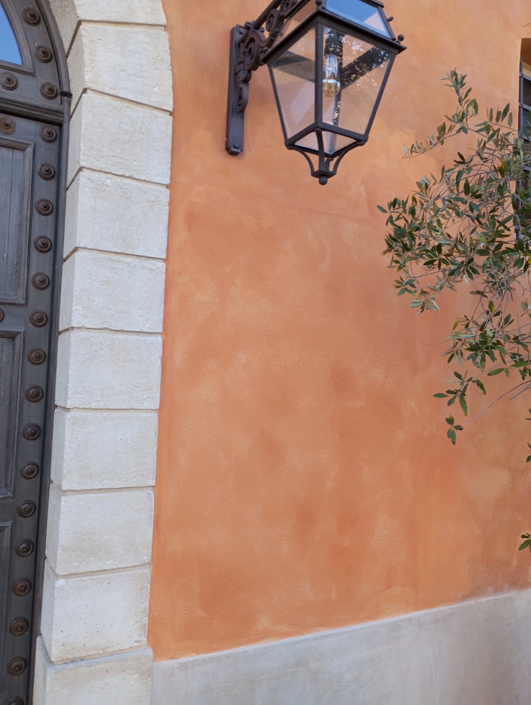 Mur en enduit décoratif terracotta avec lanterne en fer forgé