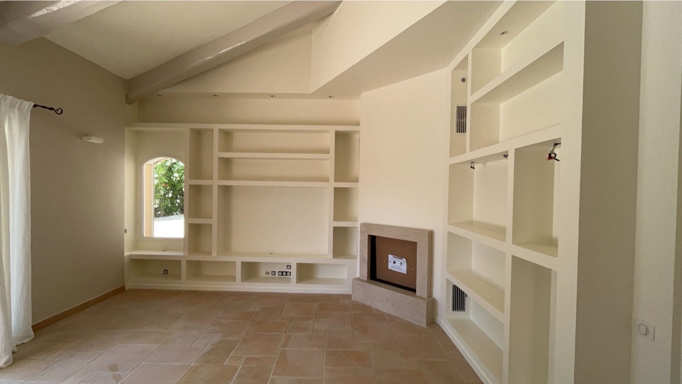 Meuble et niches en plâtre crème finition mate, avec cheminée intégrée