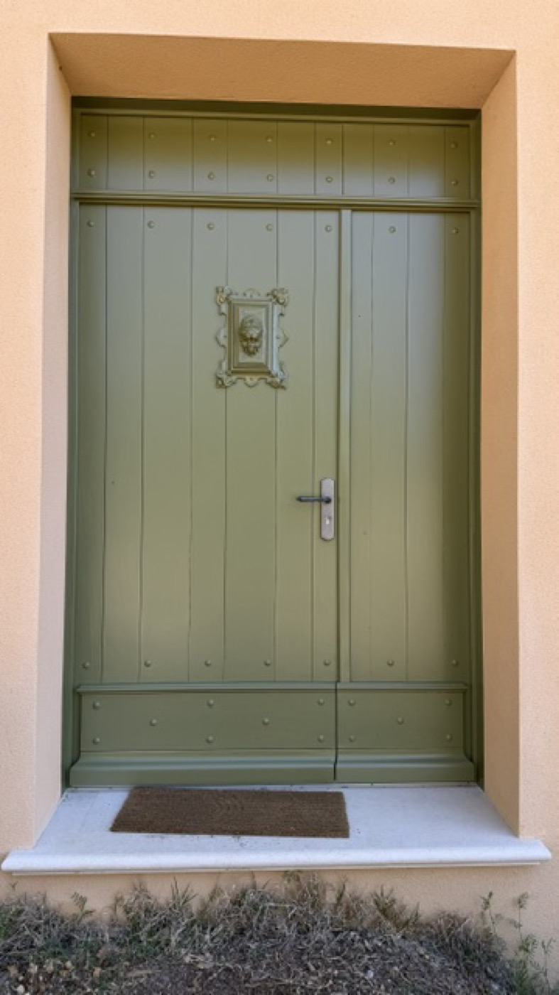 Porte cochère double en bois vert sauge, façade en pierre