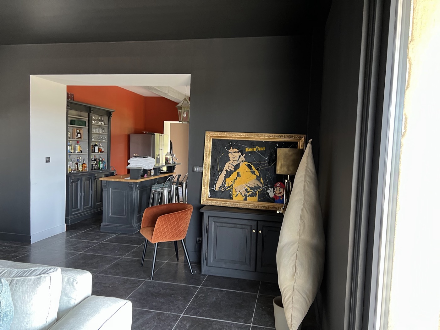 Salon contemporain aux murs anthracite mat, ouverture sur cuisine terracotta